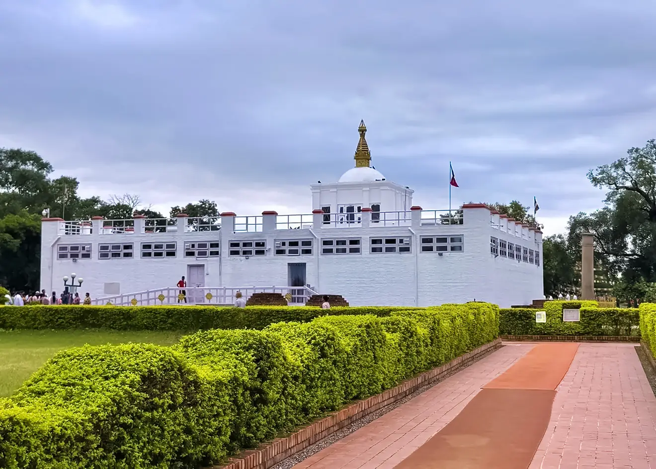 The historic white Maya Devi Temple stands beside the ancient Ashoka Pillar. This 6-meter sandstone column is a key highlight in any Lumbini Travel Guide.