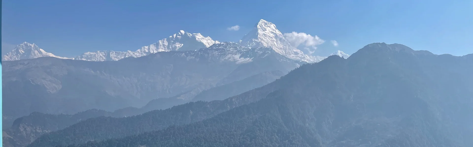 A panoramic view of snow-capped Himalayan peaks under a clear blue sky. These sharp ridges represent the best time for hiking in Nepal for mountain lovers.