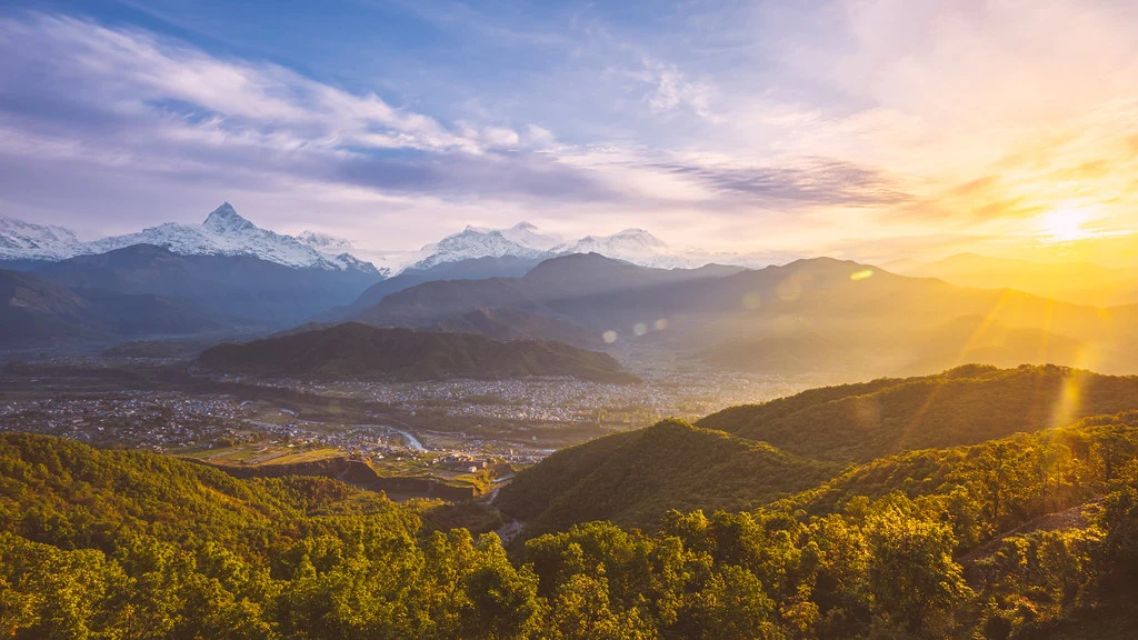 A breathtaking Himalayan sunrise over Pokhara, Nepal. Experience views like this on your Nepal itinerary for 7 days, blending luxury with dramatic mountain vistas from above the misty valley.