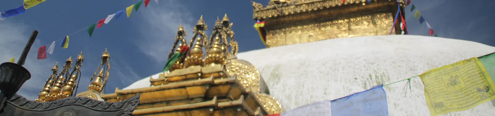 The large, white Swayambhunath Stupa dome with gold top and red spire stands in Kathmandu, an essential sight to include in your Nepal Travel Budget Guide.