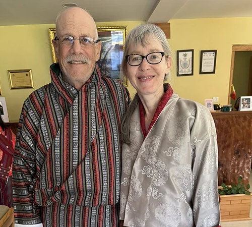 A happy couple wears traditional Bhutanese clothing during their Essential Bhutan Travel Tour, showcasing authentic cultural immersion and personalized travel experiences in the Himalayas.