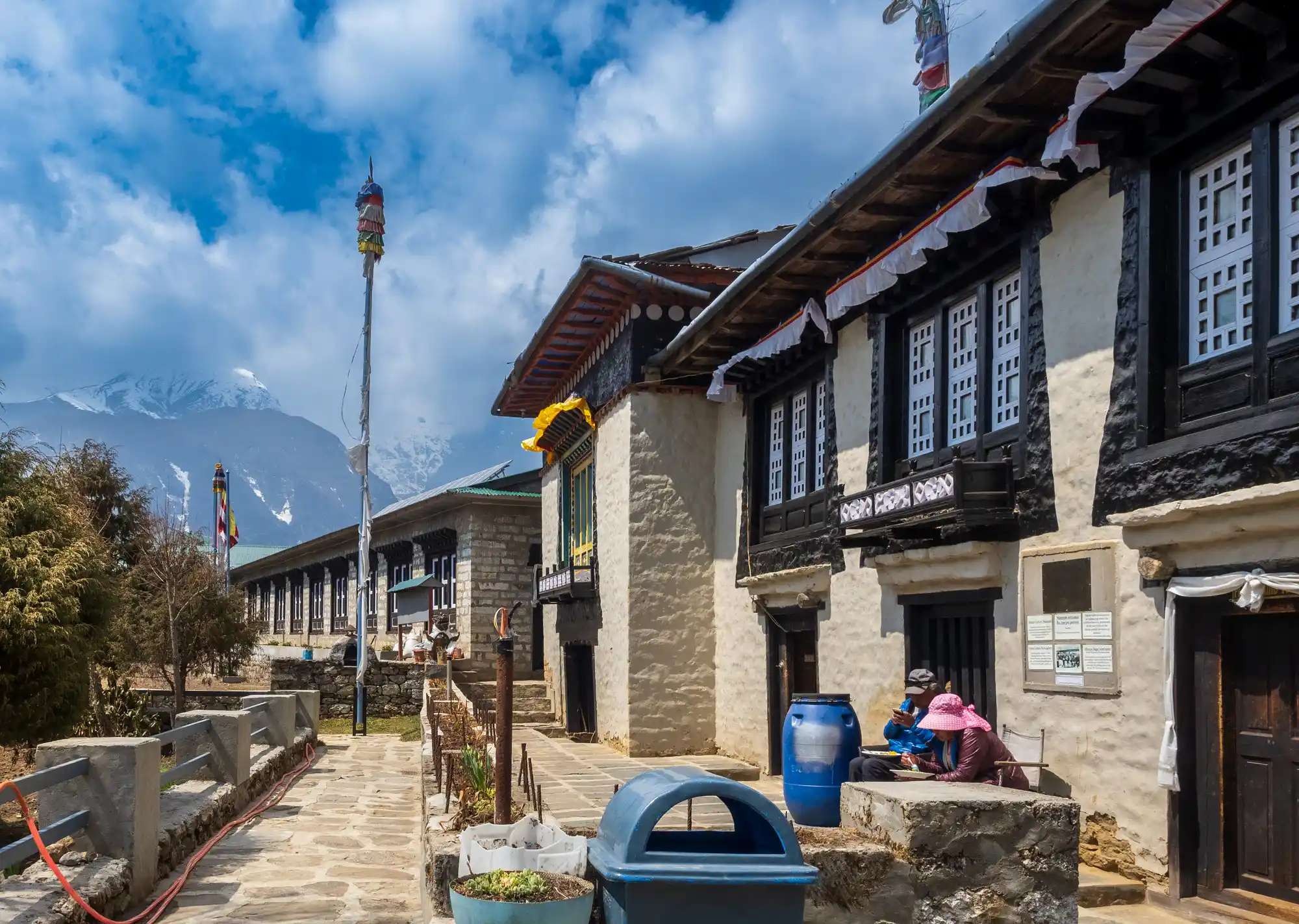 Traditional stone buildings of the Sherpa Museum in Namche Bazaar stand under a blue sky, offering a rich historical stop during an Everest Cultural Trek.