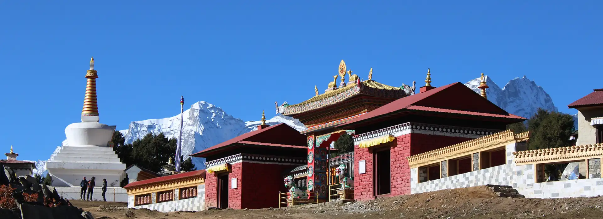The historic Tengboche Monastery sits prominently on a high ridge during a clear morning, with major snow-capped Himalayan peaks towering in the background along the Everest Cultural Trek.