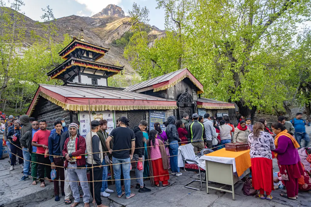 A long queue of visitors waits outside the sacred Muktinath Temple nestled in the mountains, a spiritual highlight often reached while Hiking in Nepal by Month.