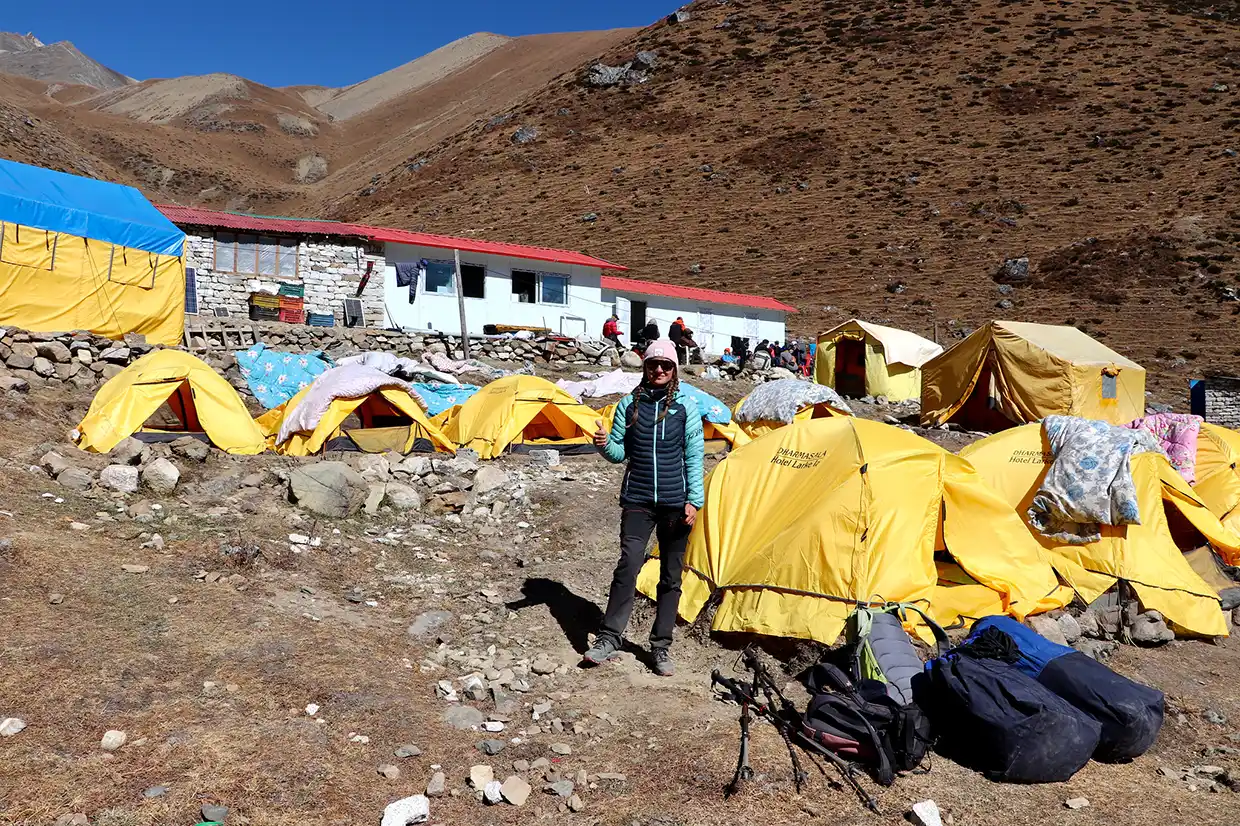 A traveler showing their passport and entry documents at an official mountain checkpoint with snowy peaks in the background, essential for a Manaslu Trek Permit Guide.